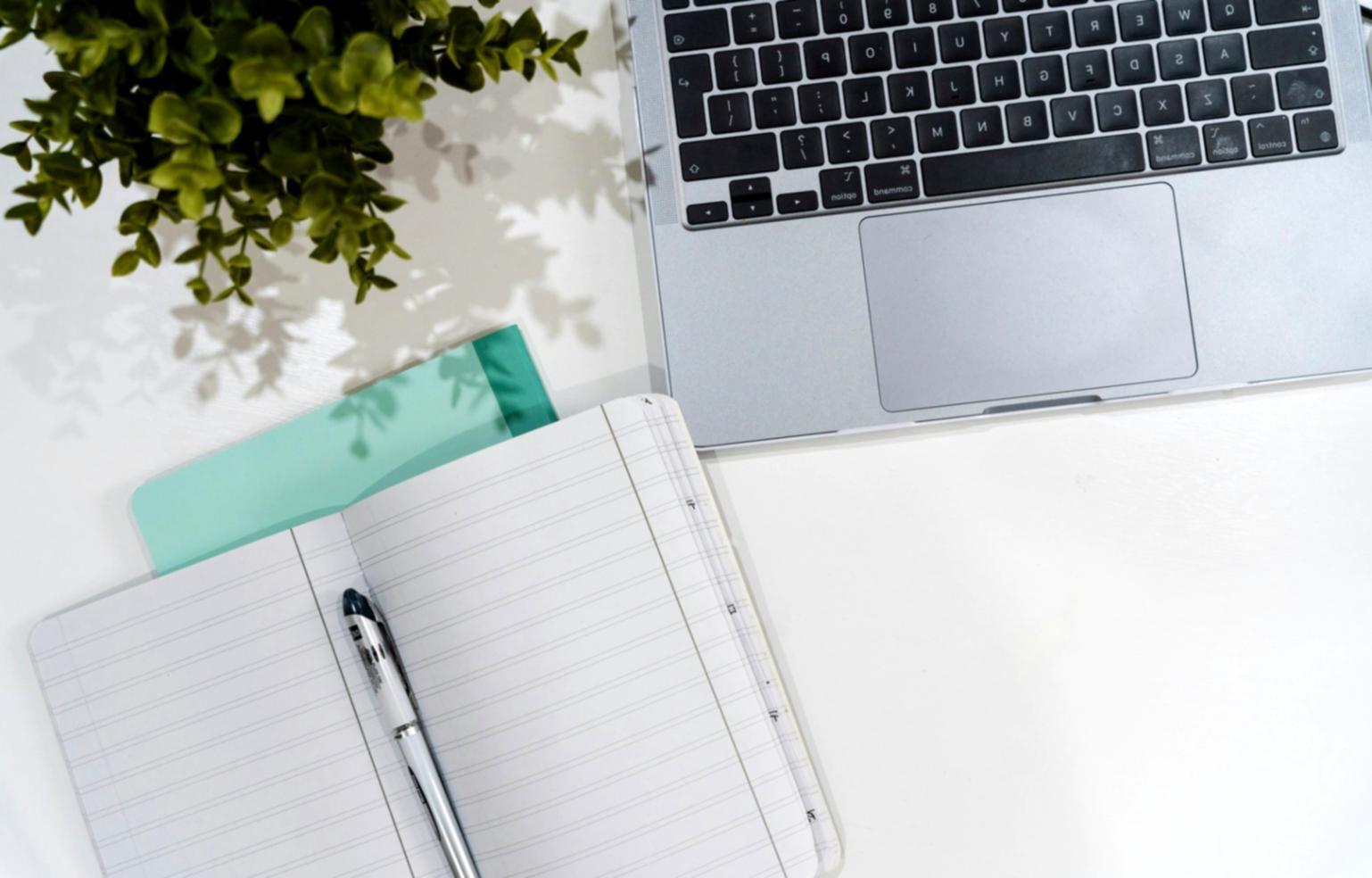 Zufriedene Kursteilnehmerin bei der Finanzplanung mit Unterlagen und Laptop